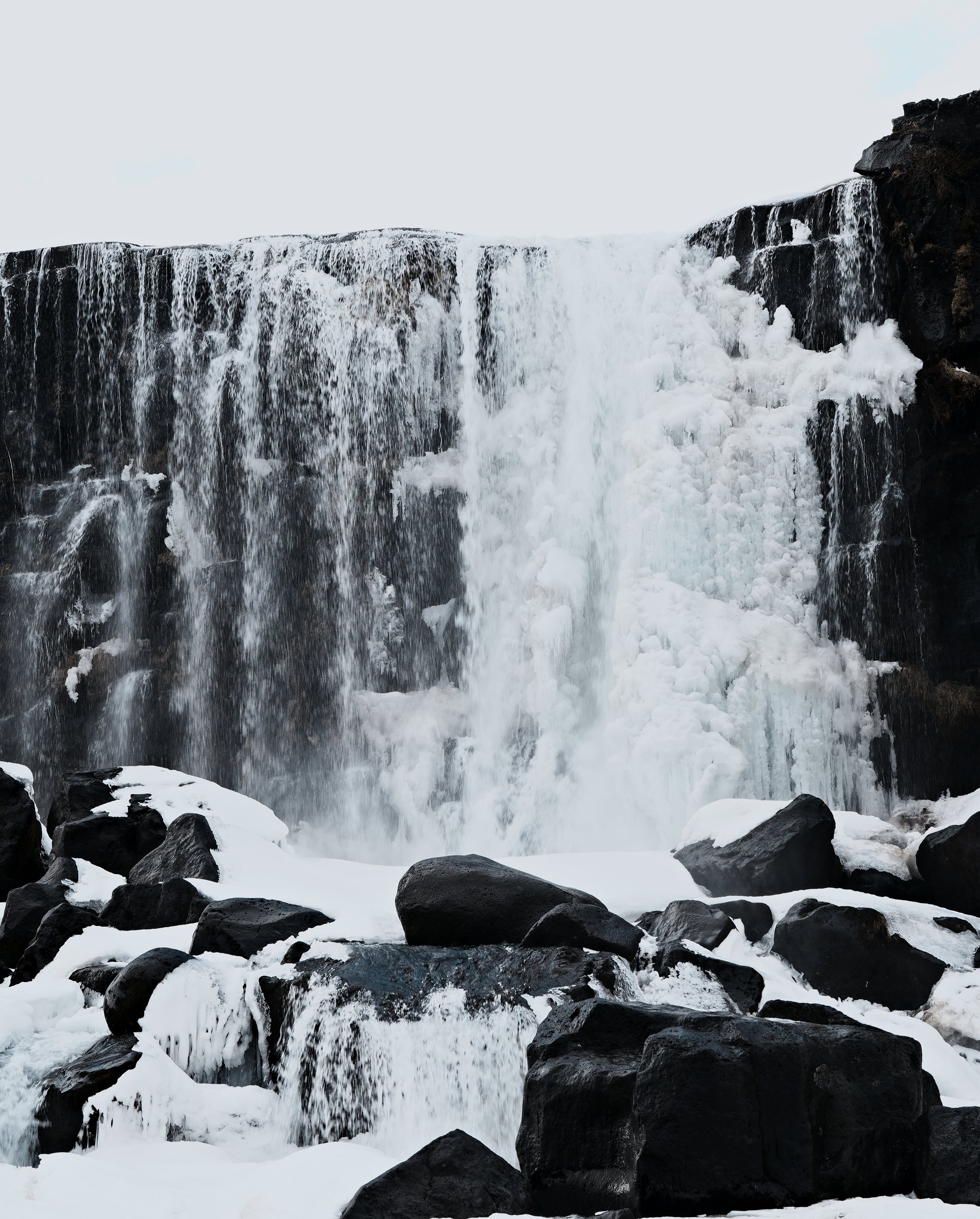 Vertical frame of the main falls: frozen columns of ice against the basalt wall.