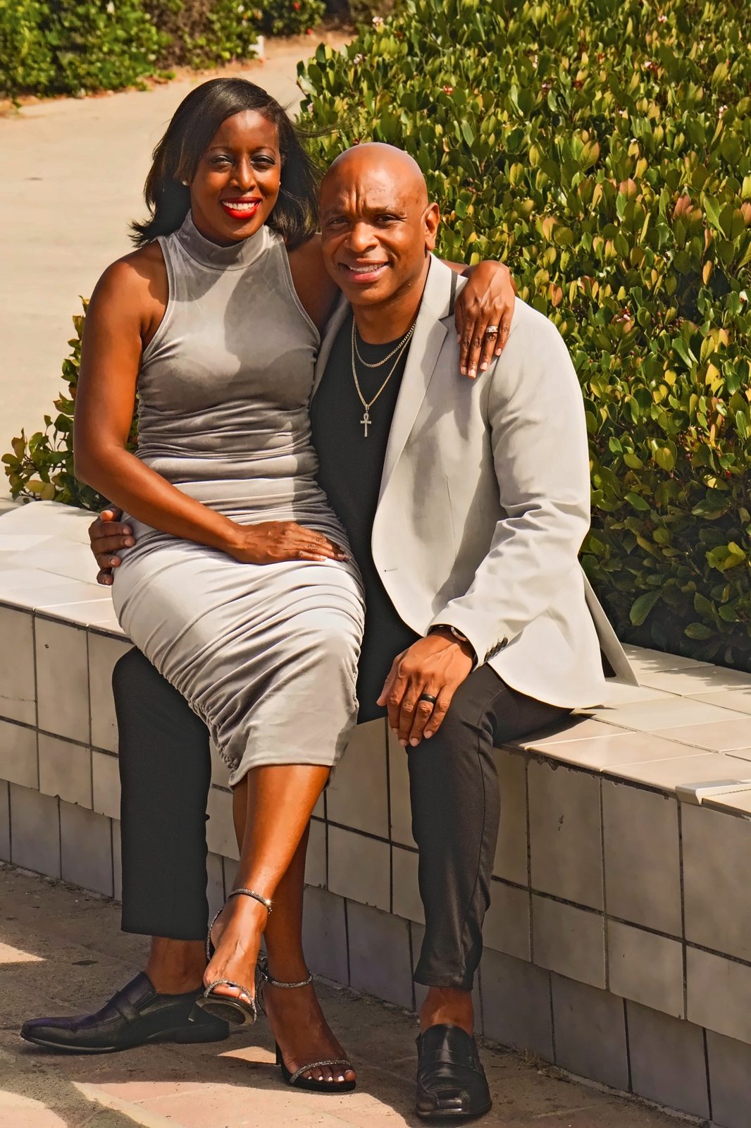 Couple seated on a tiled wall, laughing