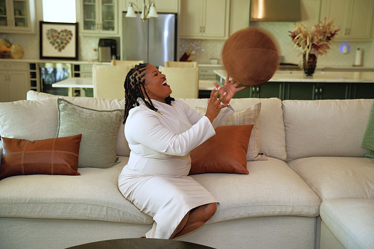 Mid-toss, leather ball in the air above her hands