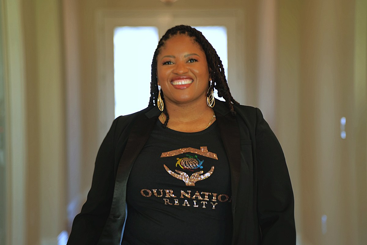 Waist-up portrait in Our Nation Realty tee and black blazer