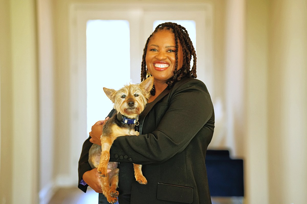 Holding a small terrier in the hallway, laughing
