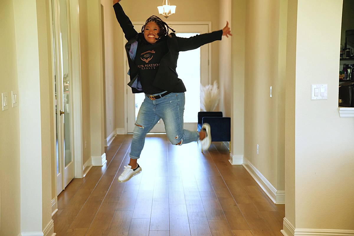Jumping mid-air in the hallway, arms out